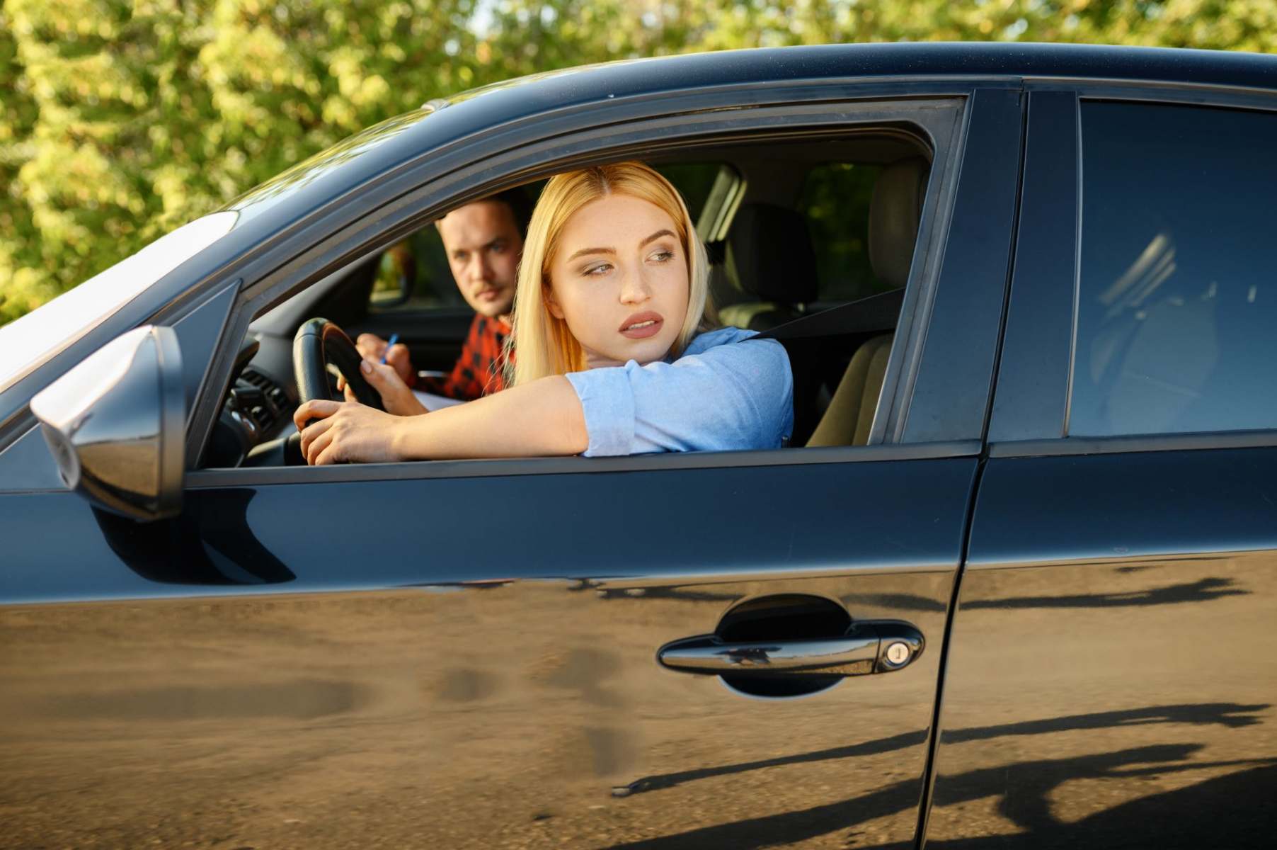 woman-and-instructor-looking-out-of-the-car-window-V574WZE